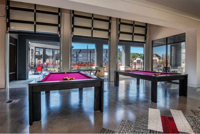 Two pool tables with natural lighting nearby