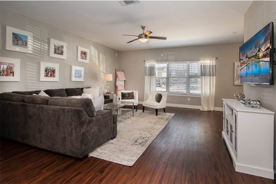 Wood-style flooring in living room with ceiling fan