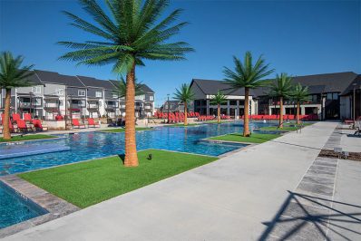resort-style pool with greenery and red pool-side seating