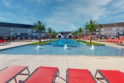 View of pool from red outdoor lounge chairs